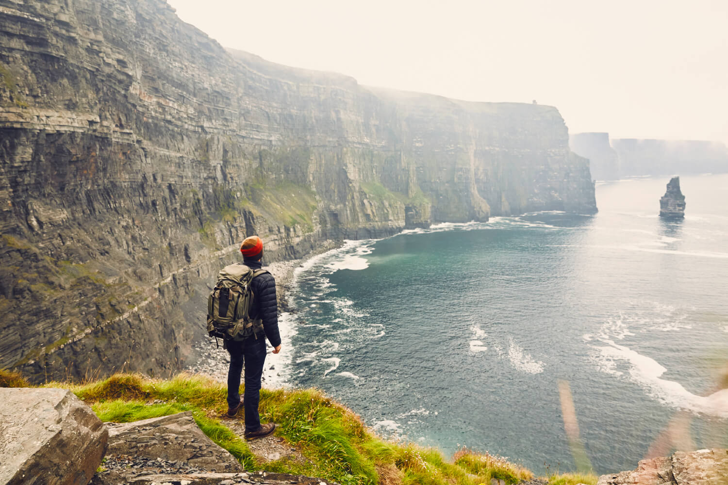 a backpacker exploring the Cliffs of Moher in Galway, Ireland