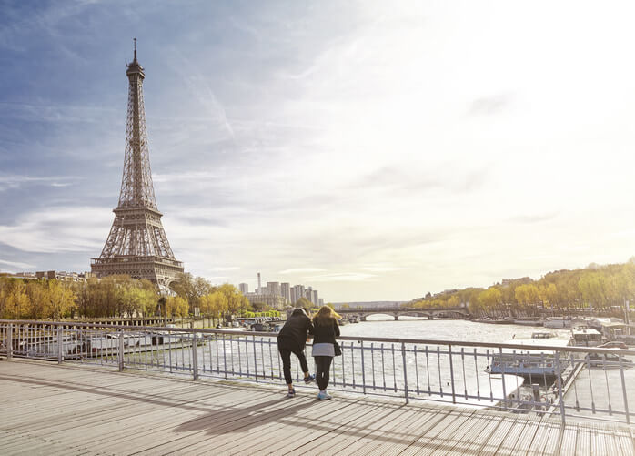 tourists walking around the Eiffel Tower in Paris, France