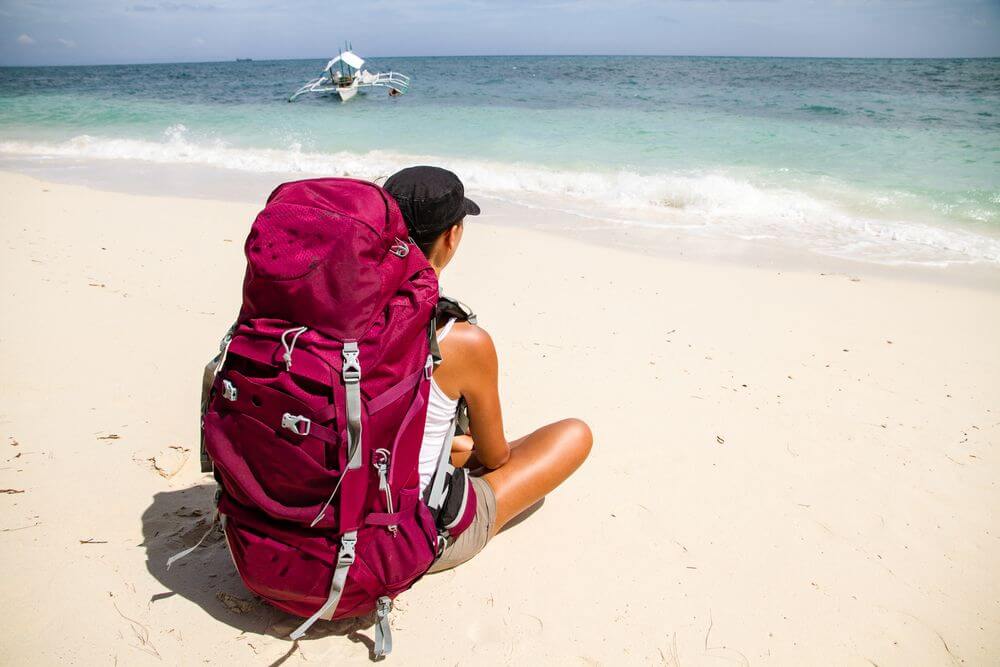 backpacker sitting on the beach