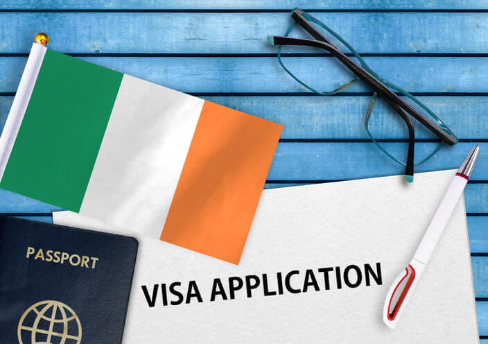 Flag of Ireland and a passport on wooden background