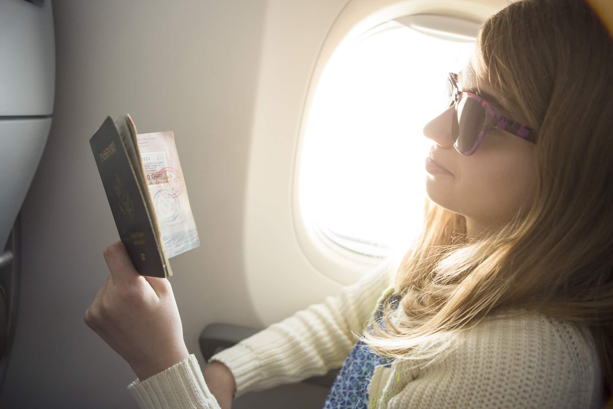 traveller checking her visa while on a plane