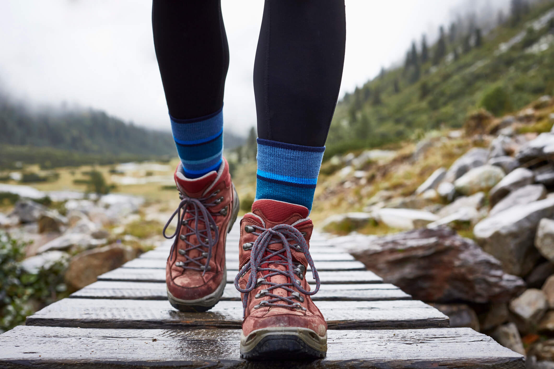 a hiker hiking across a wooden footbridge