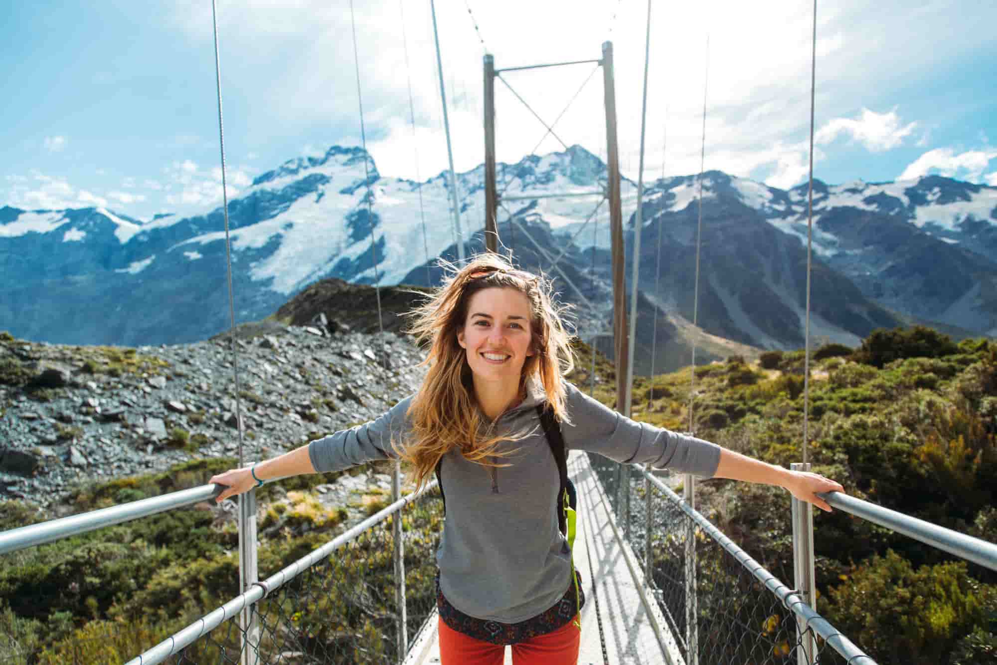 girl on a swing bridge on the Hooker Valley trail in New Zealand