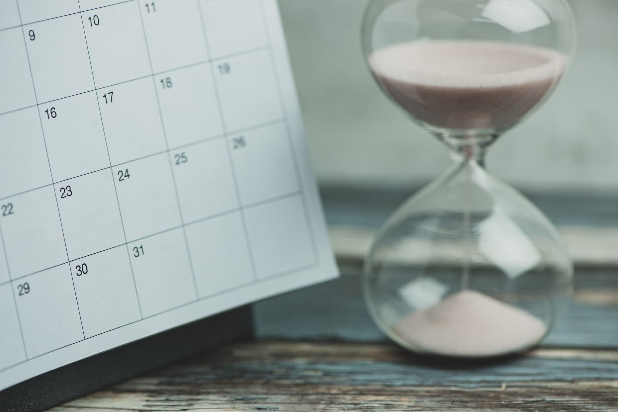 calendar and hourglass on a wooden table