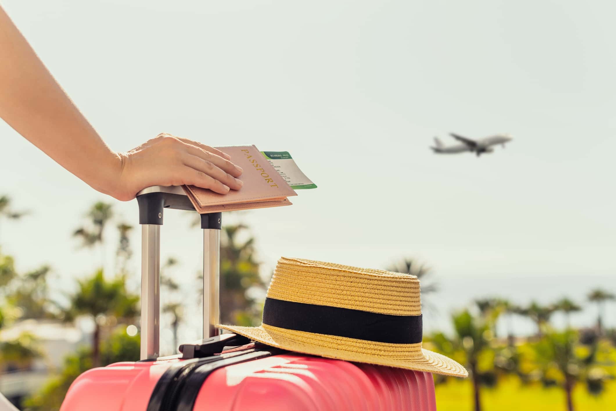 woman holding her pink suitcase and passport